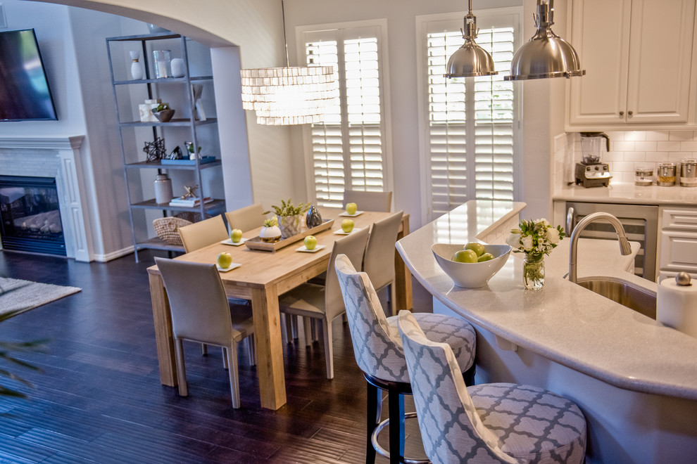 Example of a large transitional u-shaped dark wood floor open concept kitchen design in Phoenix with recessed-panel cabinets, white cabinets, marble countertops, white backsplash, an island, a drop-in sink, subway tile backsplash and stainless steel appliances