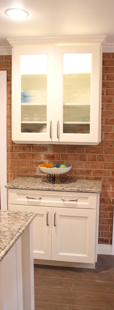 Mid-sized transitional u-shaped porcelain tile and brown floor eat-in kitchen photo in DC Metro with an undermount sink, recessed-panel cabinets, white cabinets, granite countertops, beige backsplash, porcelain backsplash, stainless steel appliances and an island