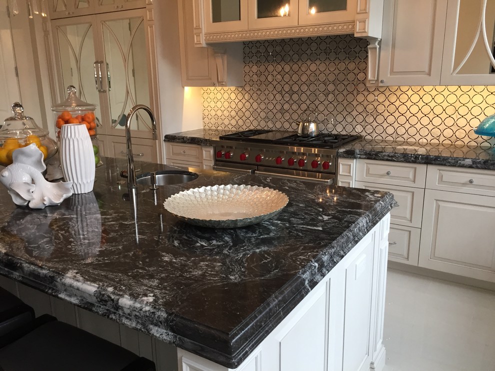 Mid-sized transitional l-shaped eat-in kitchen in Phoenix with an undermount sink, raised-panel cabinets, white cabinets, marble benchtops, multi-coloured splashback, glass sheet splashback, stainless steel appliances, with island, marble floors and white floor.