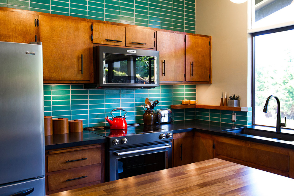 Photo of a midcentury kitchen in Sacramento with dark wood cabinets, green splashback, ceramic splashback and with island.