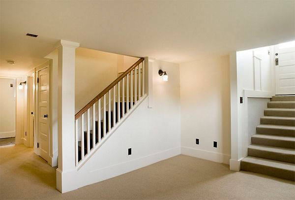 Design ideas for a large modern basement in Raleigh with white walls, carpet and beige floor.