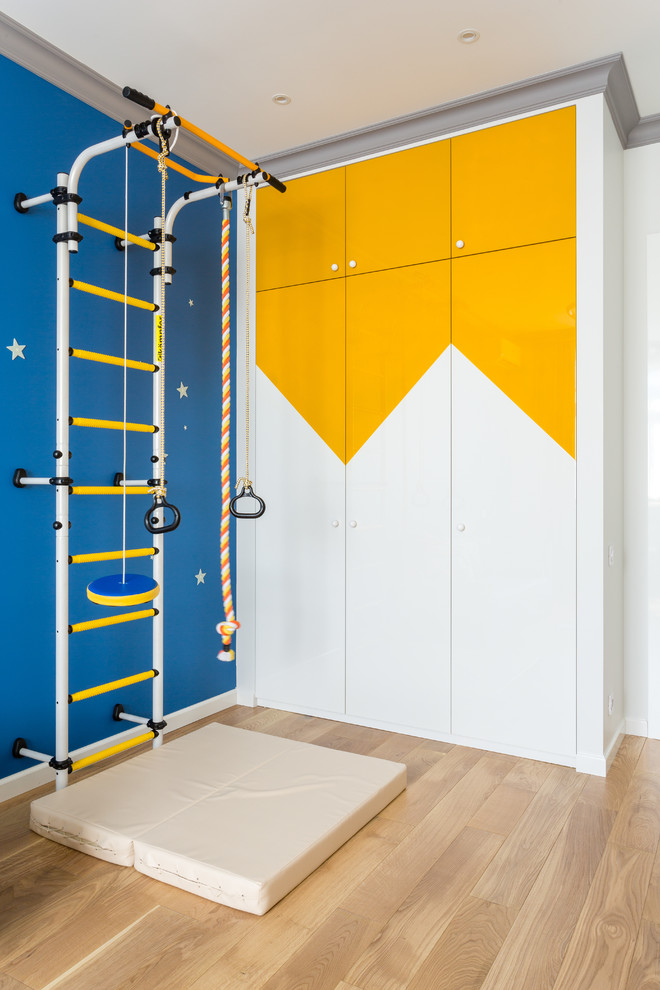 This is an example of a mid-sized contemporary kids' room for boys in Moscow with blue walls, light hardwood floors and beige floor.