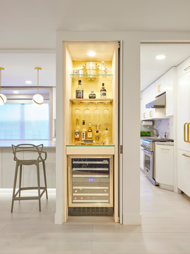 Small contemporary single-wall home bar in New York with glass benchtops and yellow splashback.