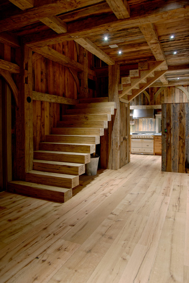 Large country wood l-shaped staircase in New York with wood risers.