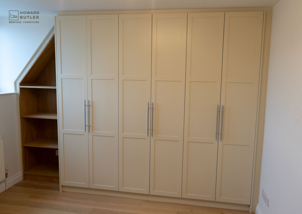 Diseño de armario y vestidor clásico grande con armarios estilo shaker, puertas de armario beige y suelo de madera clara