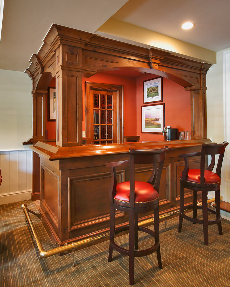 Photo of a small traditional l-shaped home bar in New York with carpet, medium wood cabinets, wood benchtops and brown benchtop.