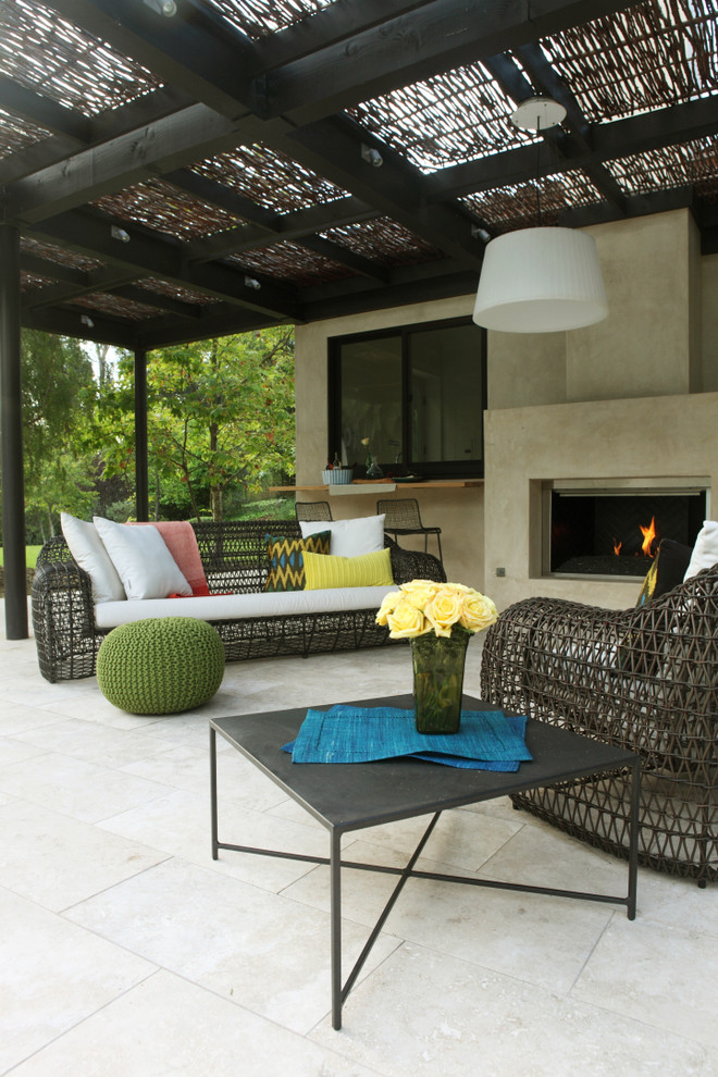 Expansive contemporary patio in Los Angeles with a gazebo/cabana, a fire feature and tile.
