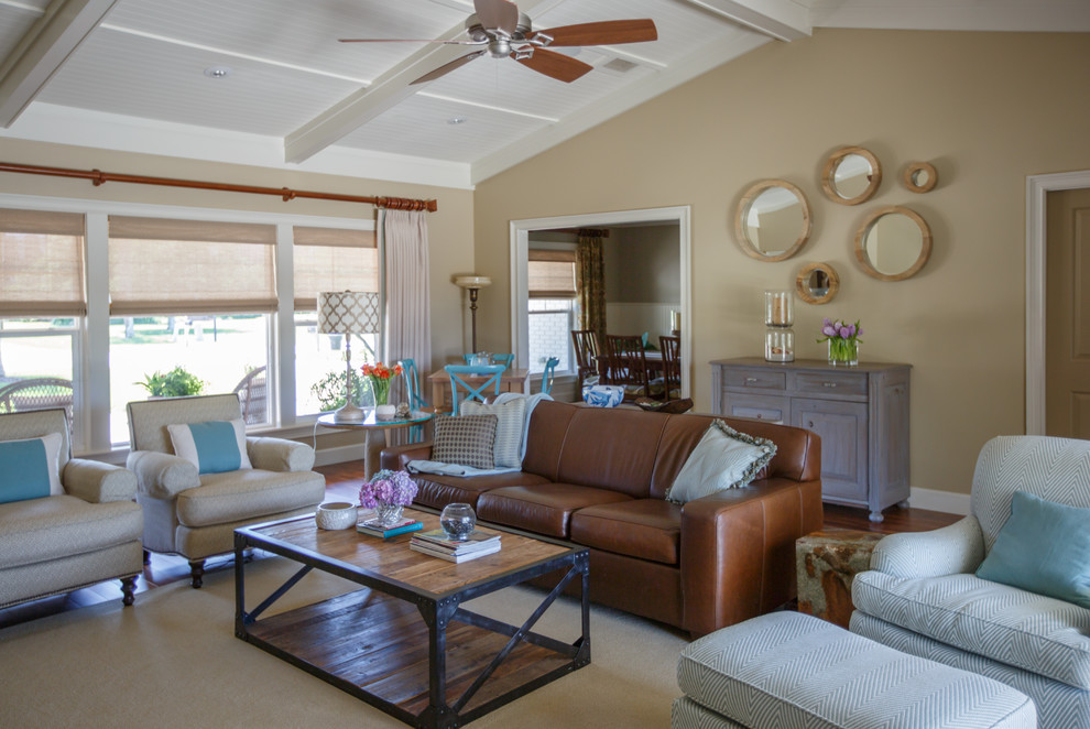 Inspiration for a large beach style open concept living room in Jacksonville with beige walls, medium hardwood floors, a standard fireplace, a tile fireplace surround and a concealed tv.