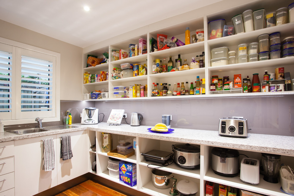 Kitchen pantry - small transitional l-shaped medium tone wood floor kitchen pantry idea in Brisbane with a single-bowl sink, flat-panel cabinets, white cabinets, granite countertops, gray backsplash, glass sheet backsplash, stainless steel appliances and no island
