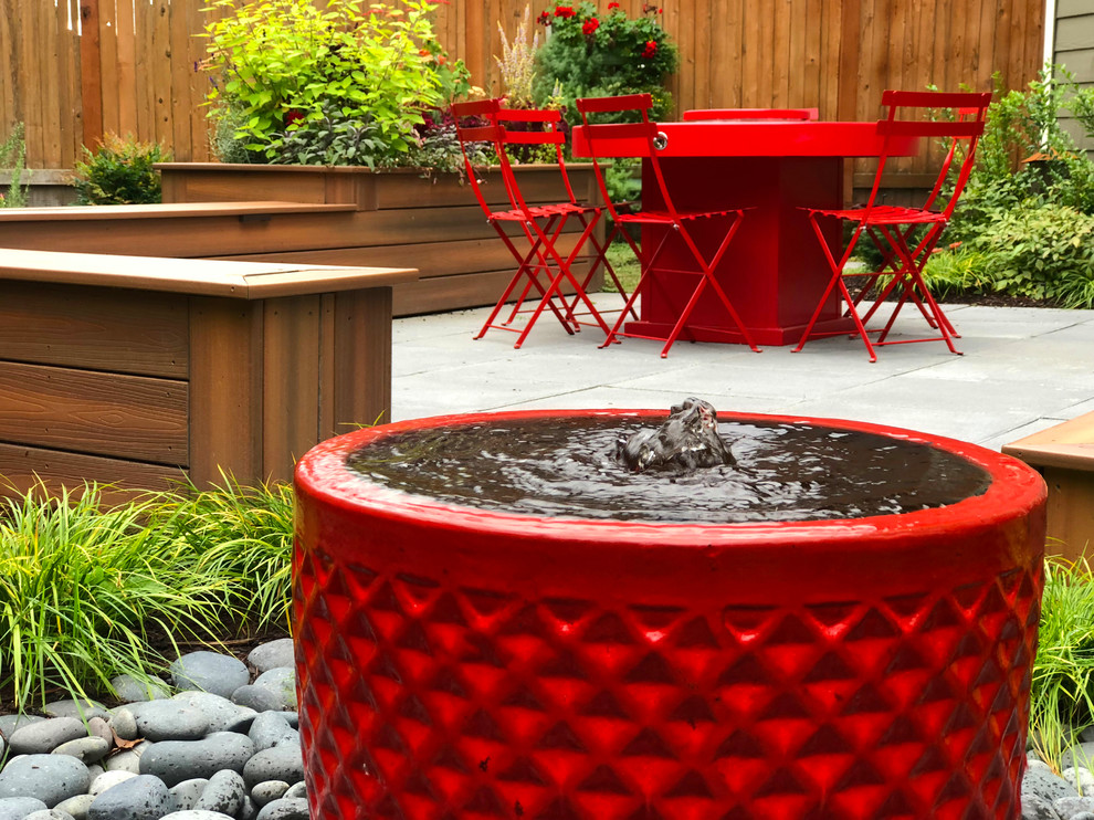 Design ideas for a backyard concrete paver water fountain landscape in Seattle.