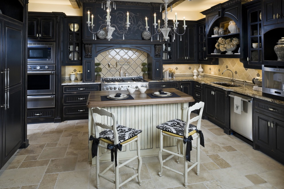 This is an example of a traditional u-shaped kitchen in Dallas with panelled appliances, granite benchtops, raised-panel cabinets, black cabinets, beige splashback and travertine floors.