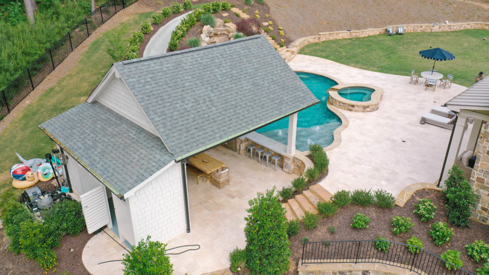 This is an example of a large traditional backyard pool in Atlanta with a pool house.
