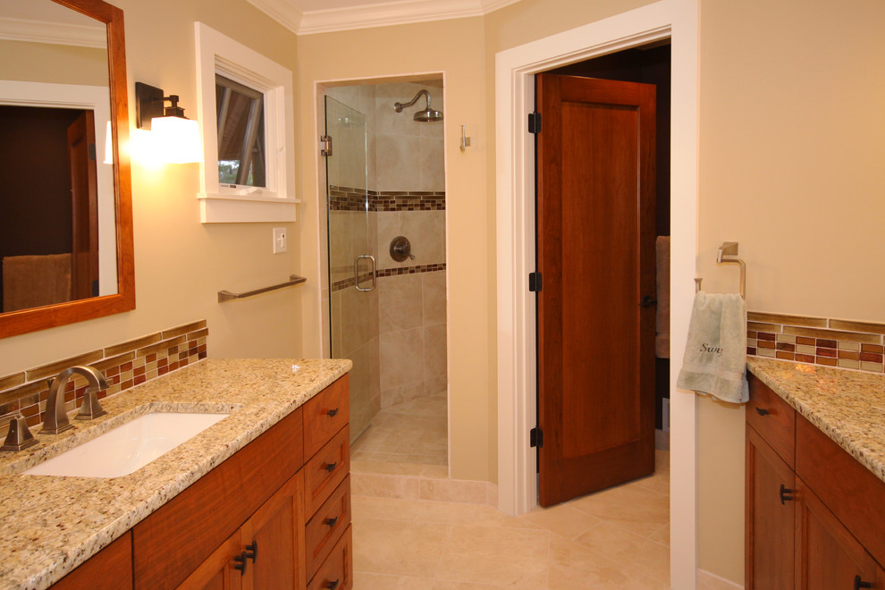 Photo of a traditional bathroom in Minneapolis with an undermount sink, flat-panel cabinets, medium wood cabinets, granite benchtops, an alcove shower, glass tile, beige walls, porcelain floors and multi-coloured tile.