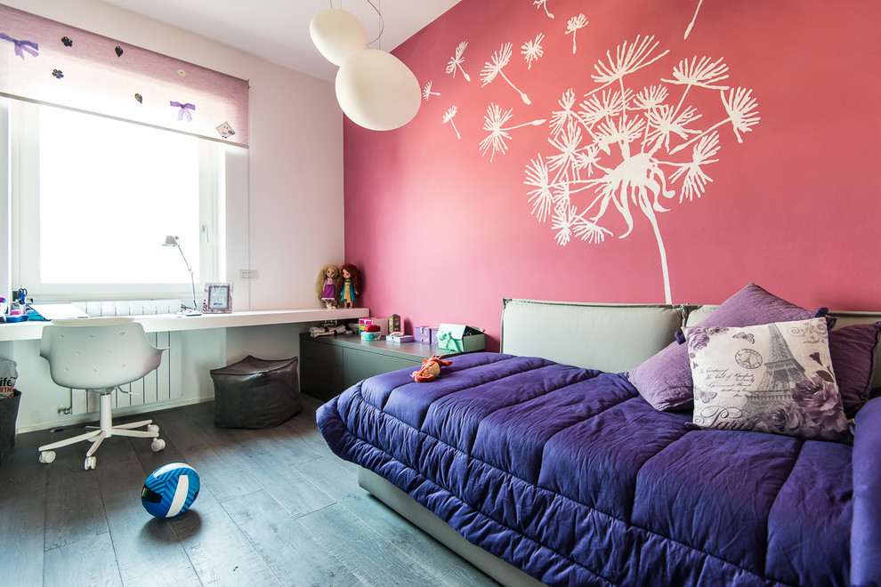 Photo of a mid-sized contemporary teen room for girls in Milan with pink walls and dark hardwood floors.