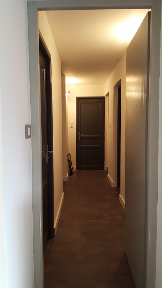 Cette image montre un couloir design de taille moyenne avec un mur blanc, un sol en liège et un sol gris.