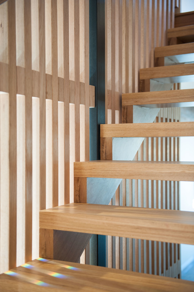 Photo of a large contemporary wood floating staircase in Brisbane with open risers.