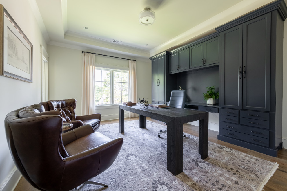 Cette photo montre un bureau tendance de taille moyenne avec un mur blanc, un sol en bois brun, un bureau indépendant et un sol marron.