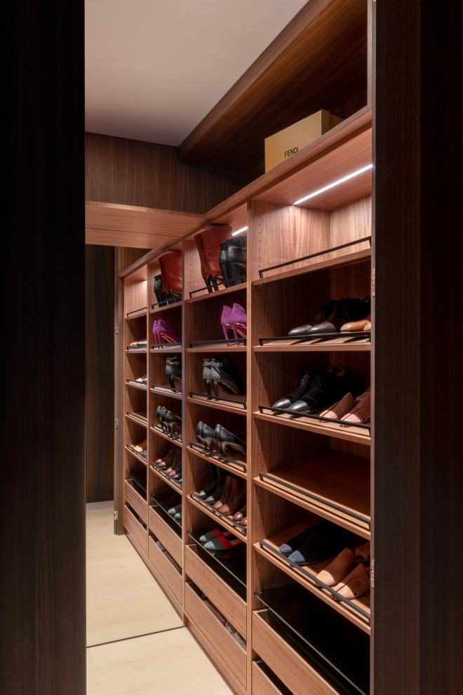 Diseño de armario vestidor unisex moderno pequeño con armarios abiertos, puertas de armario de madera en tonos medios, suelo de madera clara y suelo beige