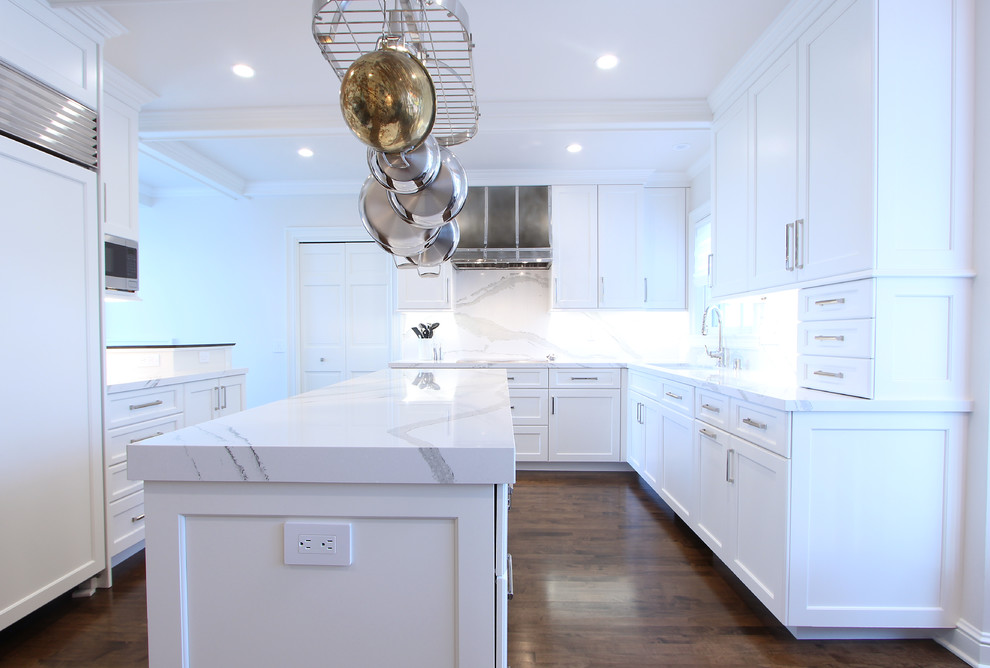 This is an example of a small traditional u-shaped eat-in kitchen in Other with an undermount sink, recessed-panel cabinets, white cabinets, quartz benchtops, white splashback, stone slab splashback, panelled appliances, dark hardwood floors, with island, brown floor and white benchtop.