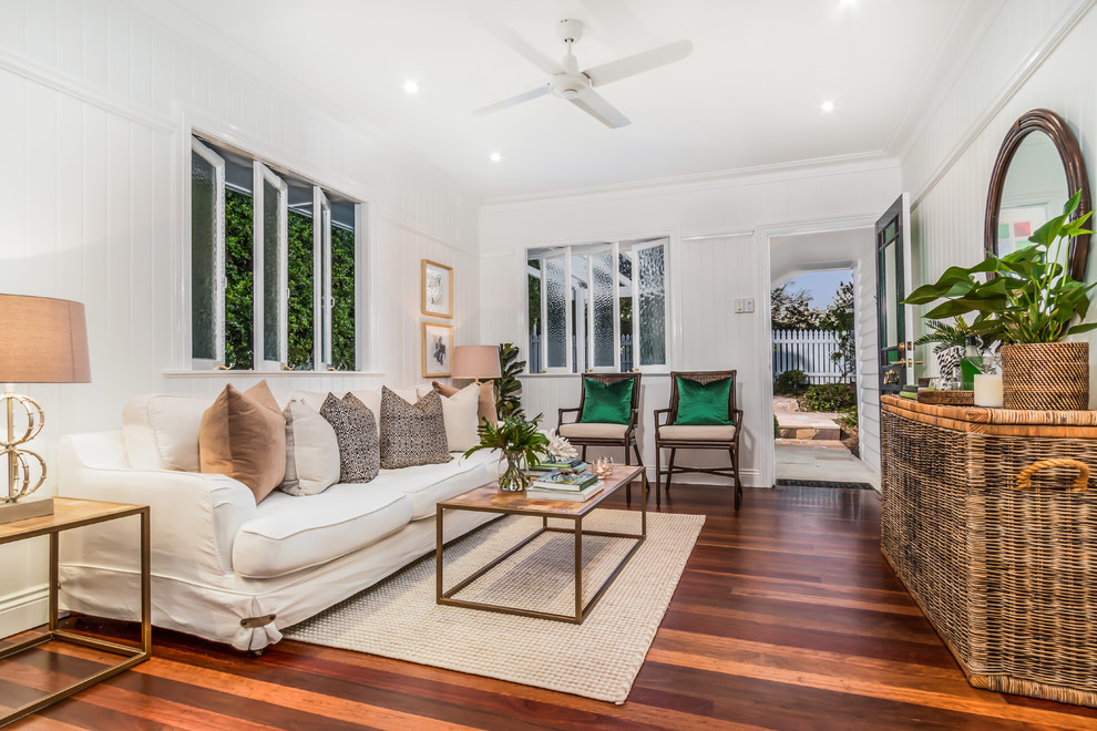 Design ideas for a small traditional living room in Townsville with white walls, medium hardwood floors and brown floor.