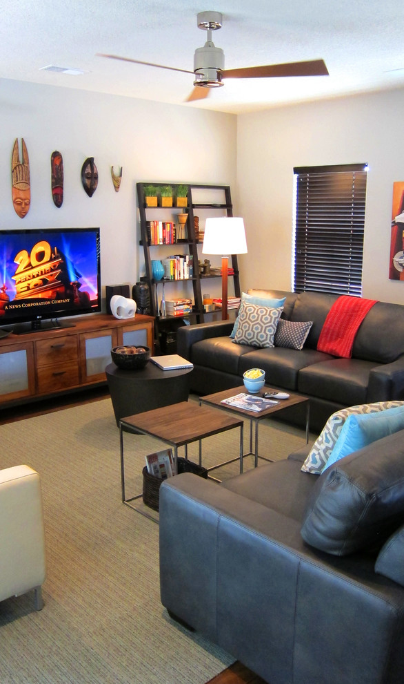 This is an example of a mid-sized contemporary open concept living room in Albuquerque with grey walls, laminate floors and a freestanding tv.