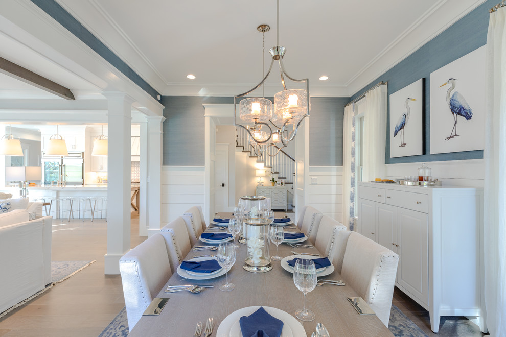This is an example of a large beach style open plan dining in Other with blue walls, medium hardwood floors and grey floor.