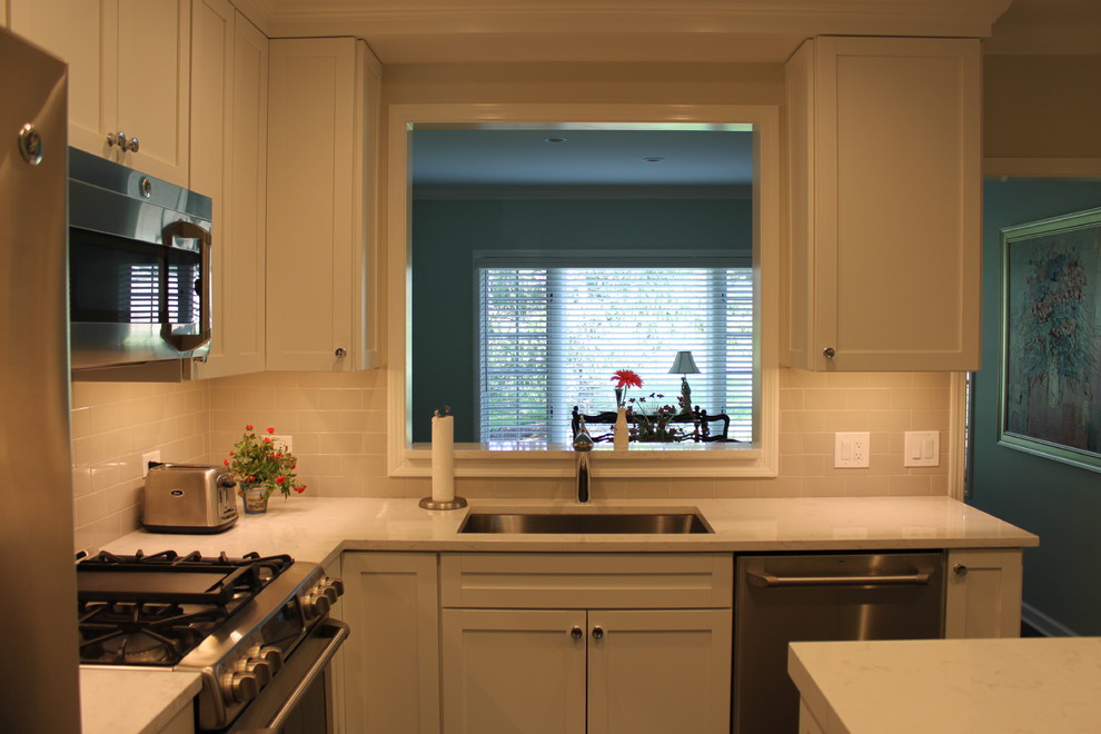Mid-sized transitional l-shaped dark wood floor and brown floor enclosed kitchen photo in Chicago with an undermount sink, recessed-panel cabinets, white cabinets, quartzite countertops, white backsplash, subway tile backsplash, stainless steel appliances and an island