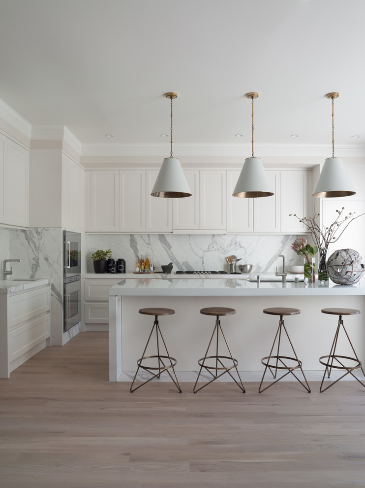 Photo of a transitional l-shaped kitchen in San Francisco with an undermount sink, shaker cabinets, white cabinets, white splashback and stainless steel appliances.