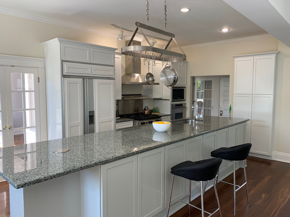 Enclosed kitchen - large transitional single-wall dark wood floor and brown floor enclosed kitchen idea in Seattle with an undermount sink, shaker cabinets, white cabinets, granite countertops, gray backsplash, metal backsplash, stainless steel appliances, an island and gray countertops