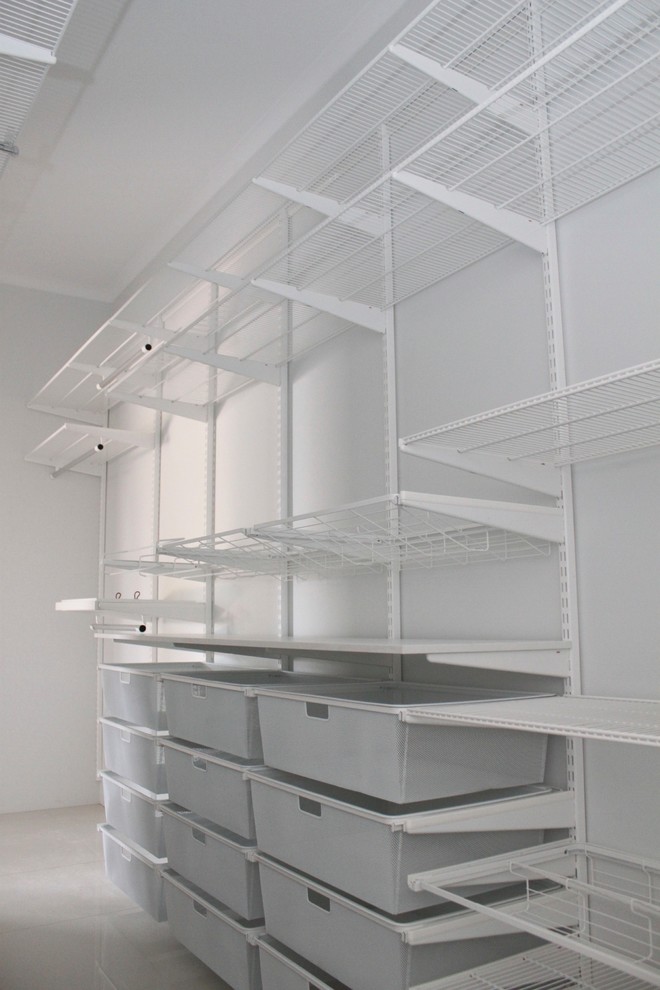 Mid-sized gender-neutral walk-in wardrobe in Darwin with open cabinets, white cabinets and porcelain floors.