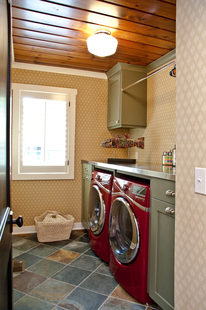 Photo of a mid-sized traditional single-wall utility room in Grand Rapids with recessed-panel cabinets, green cabinets, stainless steel benchtops, a side-by-side washer and dryer, beige walls, dark hardwood floors and brown floor.