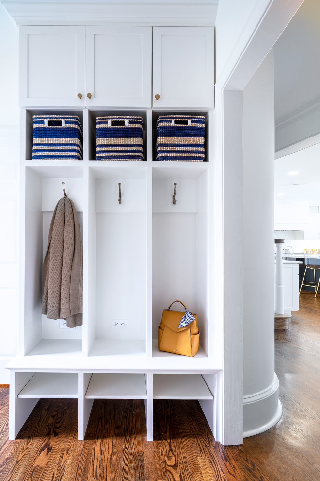 Photo of a transitional mudroom in Philadelphia with white walls, dark hardwood floors and brown floor.