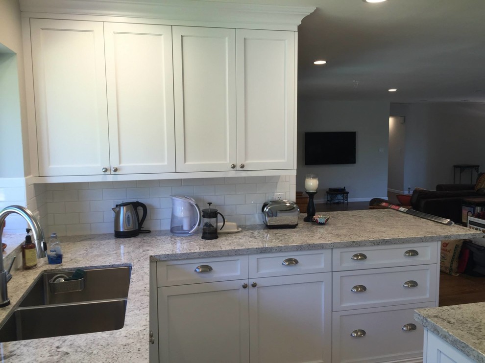 Kitchen - large transitional medium tone wood floor kitchen idea in Phoenix with an undermount sink, shaker cabinets, white cabinets, granite countertops, white backsplash, subway tile backsplash, stainless steel appliances and an island
