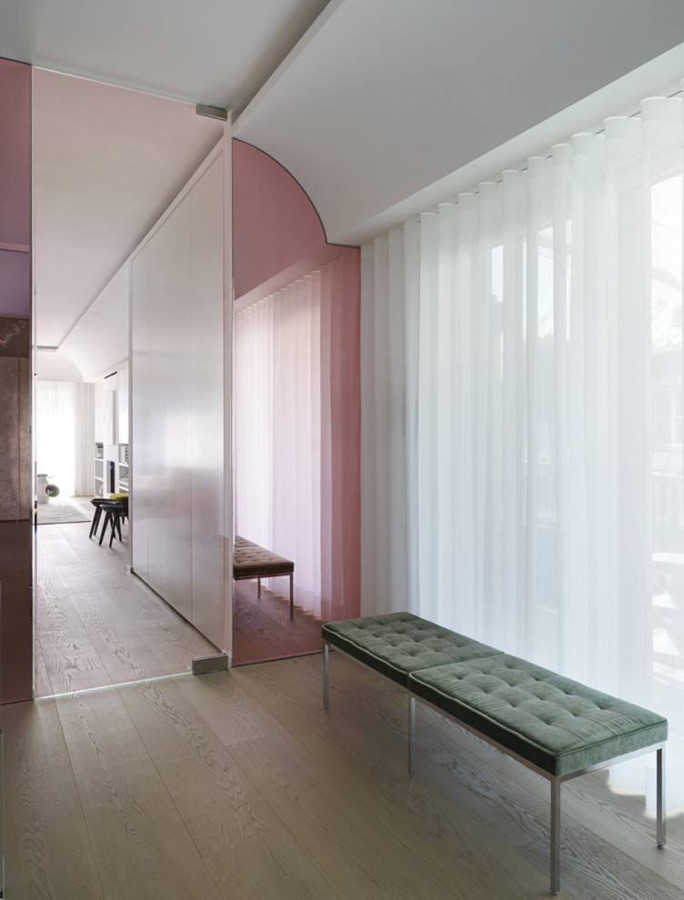 Ispirazione per un ingresso contemporaneo di medie dimensioni con pareti bianche, parquet chiaro, una porta a pivot, pavimento grigio e soffitto a volta