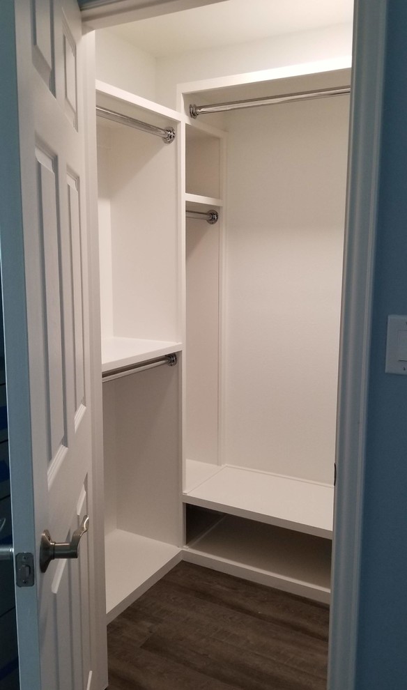 Mid-sized transitional gender-neutral walk-in wardrobe in Dallas with open cabinets, white cabinets, laminate floors and brown floor.