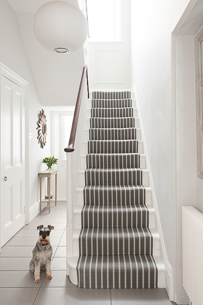 Traditional painted wood u-shaped staircase in Kent with painted wood risers.