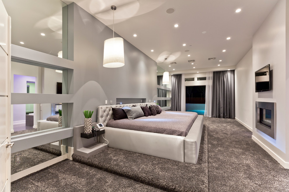 This is an example of a contemporary bedroom in Las Vegas with grey walls, carpet and a ribbon fireplace.