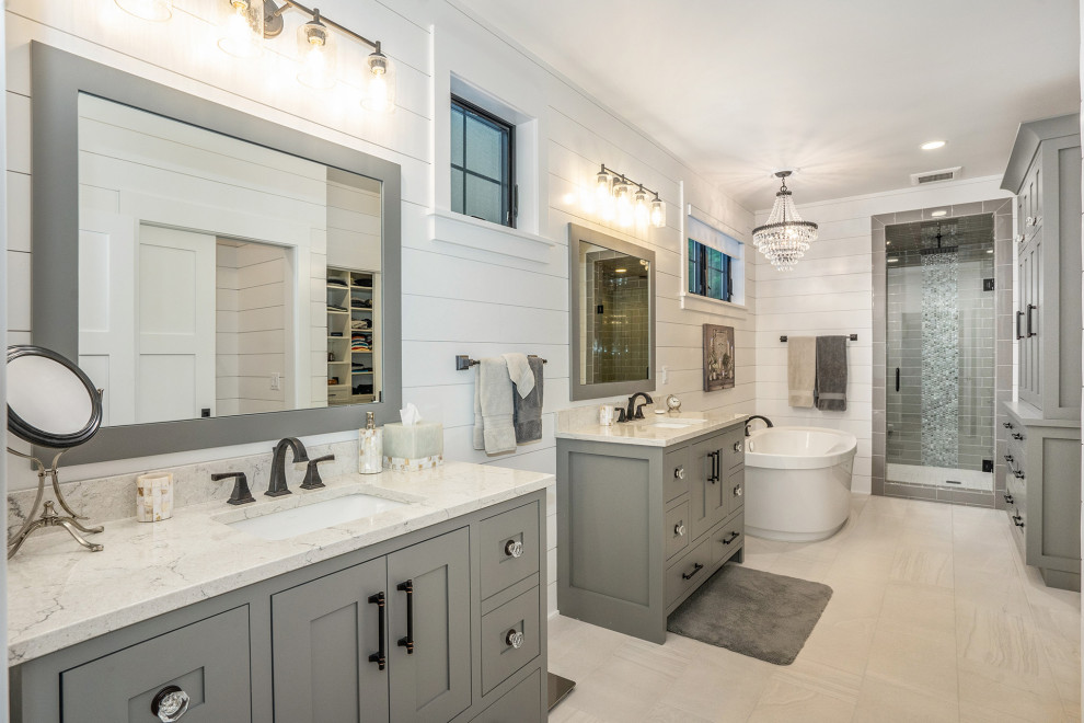 Inspiration for a transitional master bathroom in Grand Rapids with shaker cabinets, grey cabinets, a freestanding tub, an alcove shower, gray tile, an undermount sink, beige floor, a hinged shower door and multi-coloured benchtops.