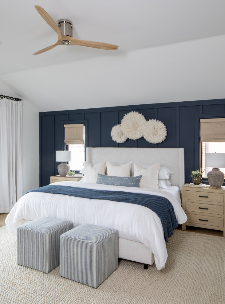 Diseño de dormitorio principal marinero de tamaño medio con paredes azules, suelo de madera en tonos medios y panelado