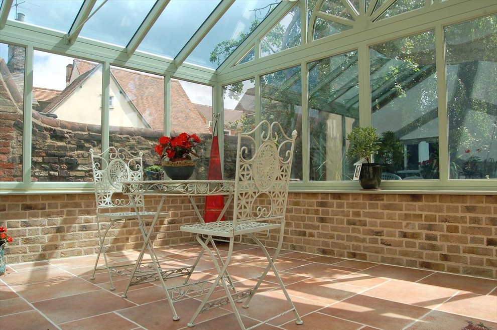 This is an example of a small traditional sunroom in Cambridgeshire with brick floors, a glass ceiling and beige floor.