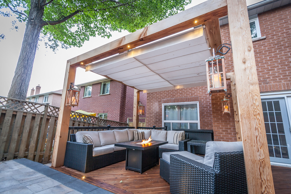 Inspiration for a traditional backyard patio in Toronto with concrete pavers and a pergola.