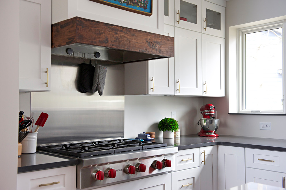 Example of a large transitional l-shaped medium tone wood floor open concept kitchen design in Indianapolis with an undermount sink, shaker cabinets, white cabinets, quartz countertops, gray backsplash, stainless steel appliances and an island