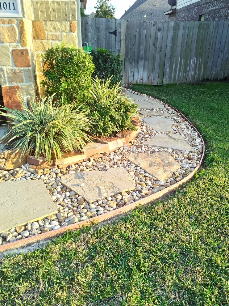 Photo of a mid-sized traditional front yard garden in Houston with mulch.