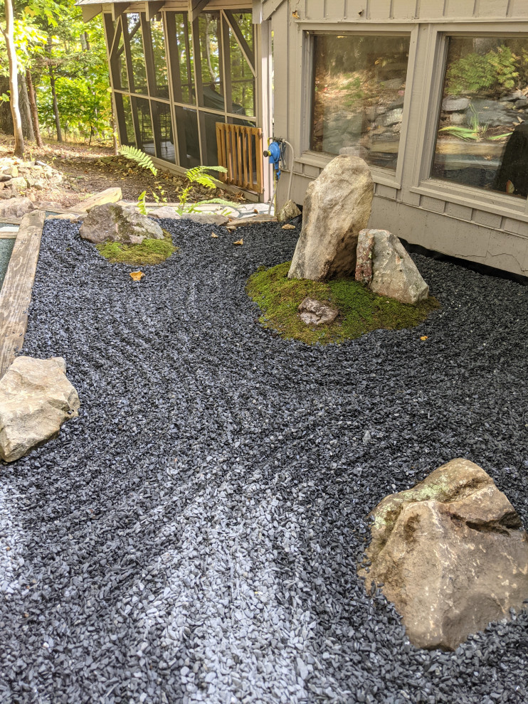 На фото: большой японский сад на боковом дворе в восточном стиле с полуденной тенью, покрытием из каменной брусчатки и с деревянным забором с