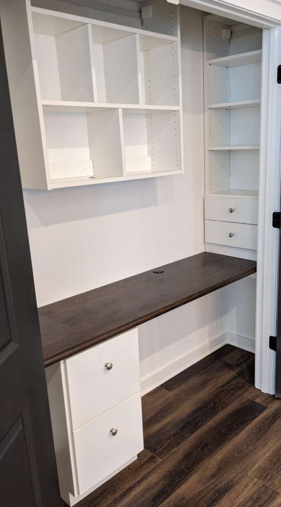 This is an example of a small modern built-in wardrobe in Birmingham with flat-panel cabinets, white cabinets and medium hardwood floors.