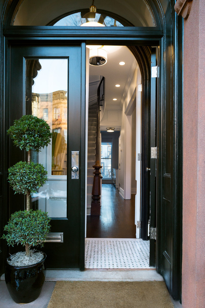 This is an example of a large transitional front door in New York with white walls, marble floors, a double front door and a black front door.