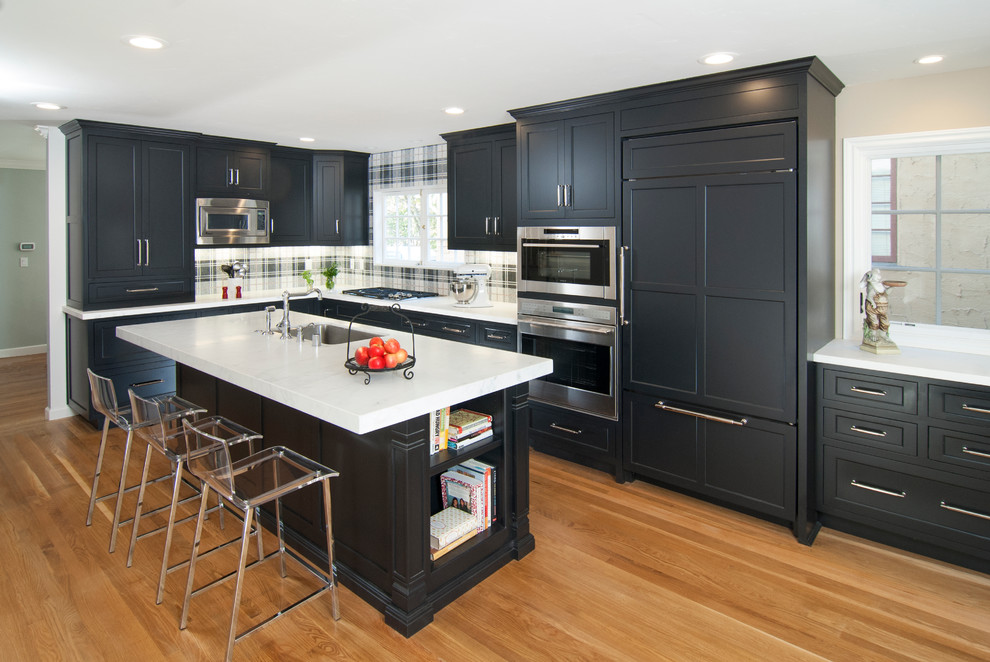 Eat-in kitchen - mid-sized transitional l-shaped light wood floor eat-in kitchen idea in Seattle with an undermount sink, recessed-panel cabinets, black cabinets, marble countertops, black backsplash, mosaic tile backsplash, paneled appliances and an island