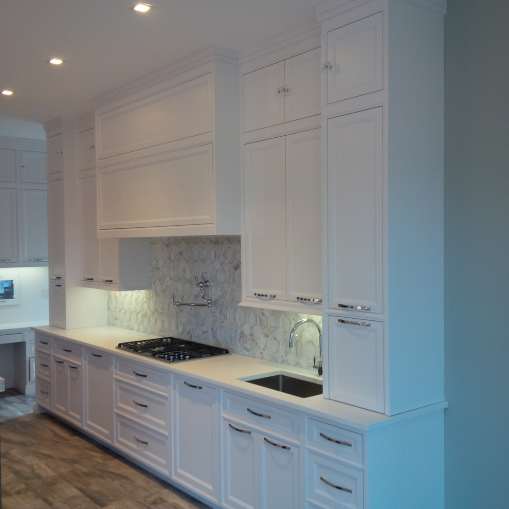 Mid-sized transitional l-shaped eat-in kitchen in New York with an undermount sink, beaded inset cabinets, white cabinets, white splashback, stainless steel appliances, porcelain floors and with island.