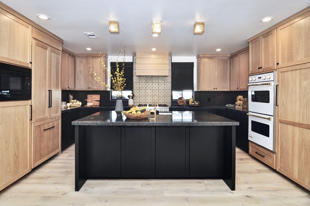 Eat-in kitchen - large transitional u-shaped light wood floor and beige floor eat-in kitchen idea in Orange County with a single-bowl sink, shaker cabinets, light wood cabinets, marble countertops, black backsplash, cement tile backsplash, white appliances, an island and black countertops