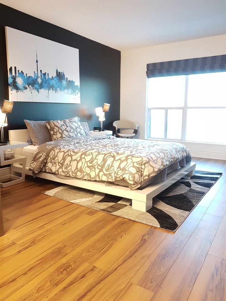 Mid-sized modern master bedroom in Toronto with black walls, laminate floors and brown floor.